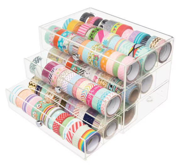 clear acrylic case with 3 pull out drawers filled with various washi tape rolls on a white table top