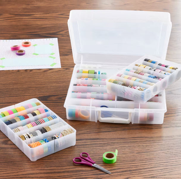 clear plastic ontainer with 4 removeable drawers in a case sitting on a table with various washi tape rolls in the trays