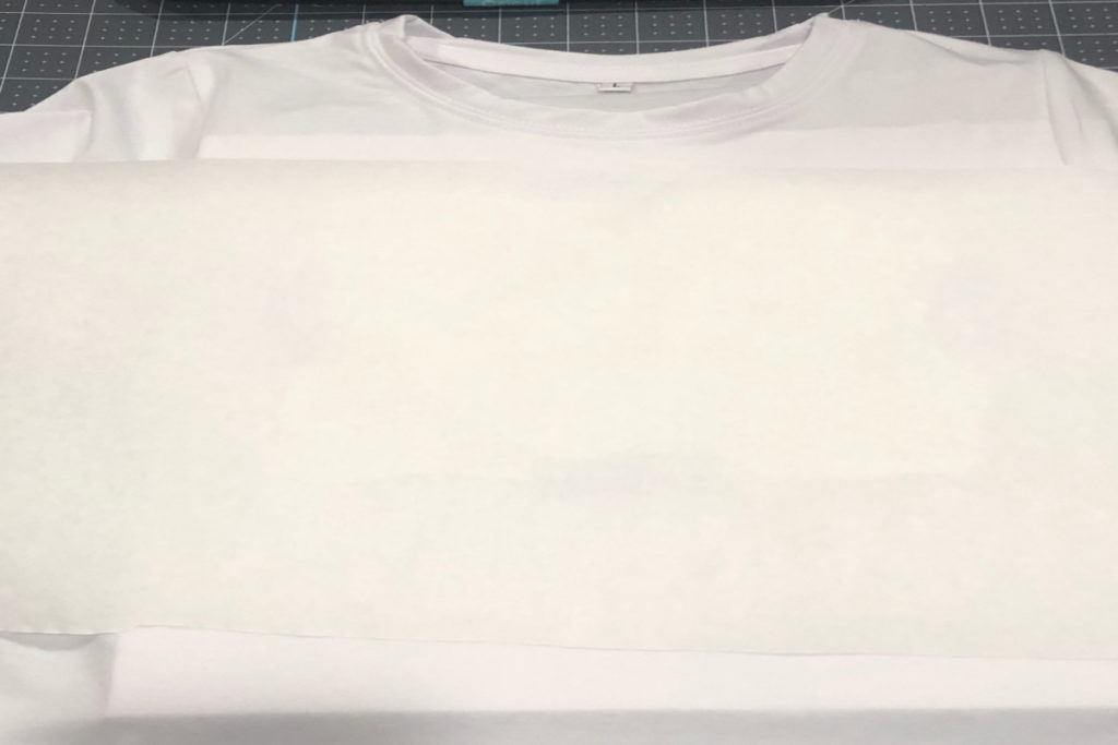 white Cricut sublimation t-shirt and sublimation print covered with sheet of white butcher paper