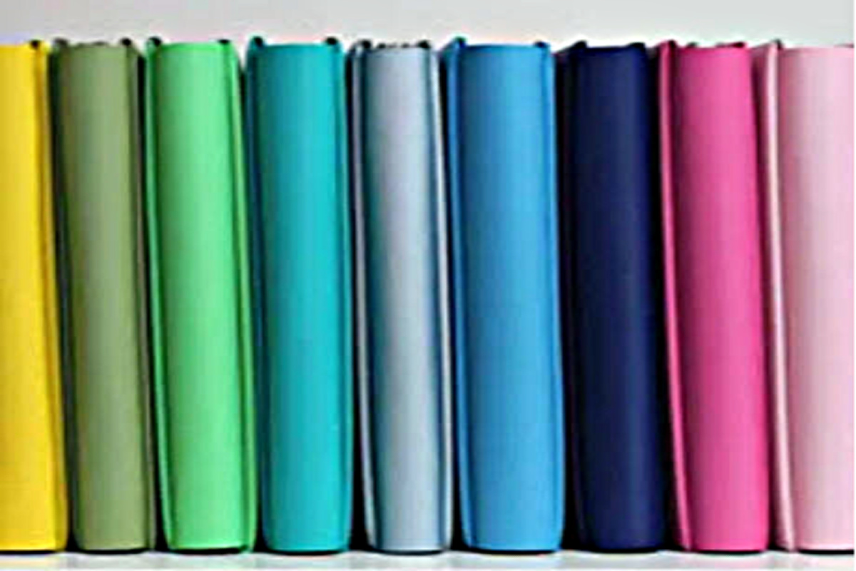 assorted colored scrapbook albums lined up on shelf